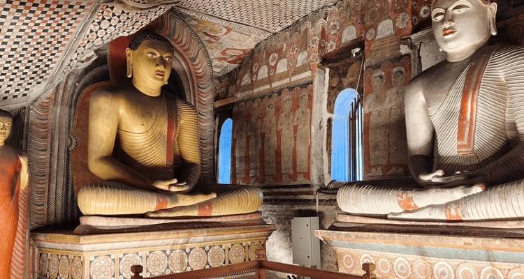 Buddha statues inside a richly decorated cave temple.