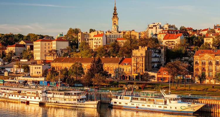Goldenes Nachmittagslicht am historischen Savamala-Flussufer von Belgrad mit an der Kaimauer vertäuten Booten.