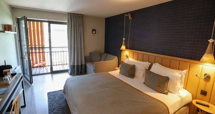 Chambre d'hôtel de style moderne avec un lit et un coin salon.