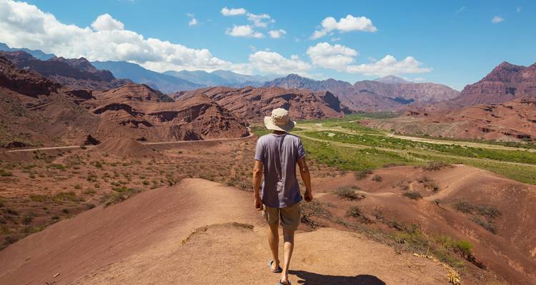 Persona caminando por una cresta en un paisaje desértico.
