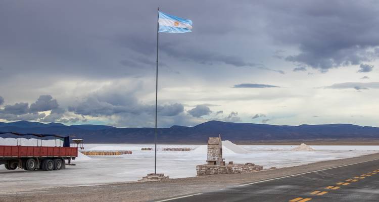 Bandera argentina ondeando sobre un salar.