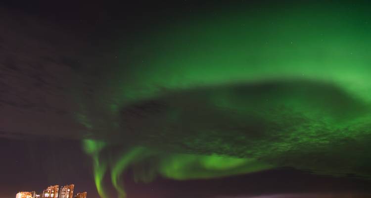 Aurora Borealis above city buildings.