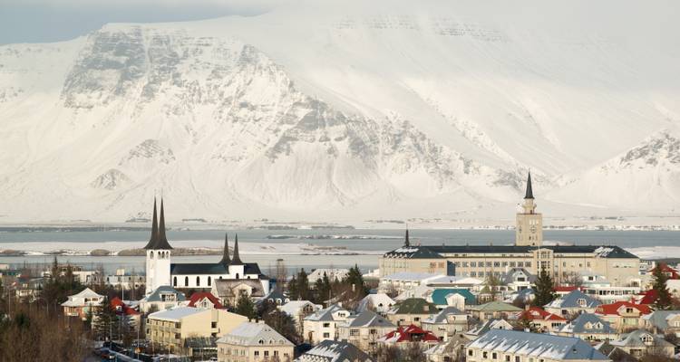 Panorama of Reykjavik with snow-capped mountains.