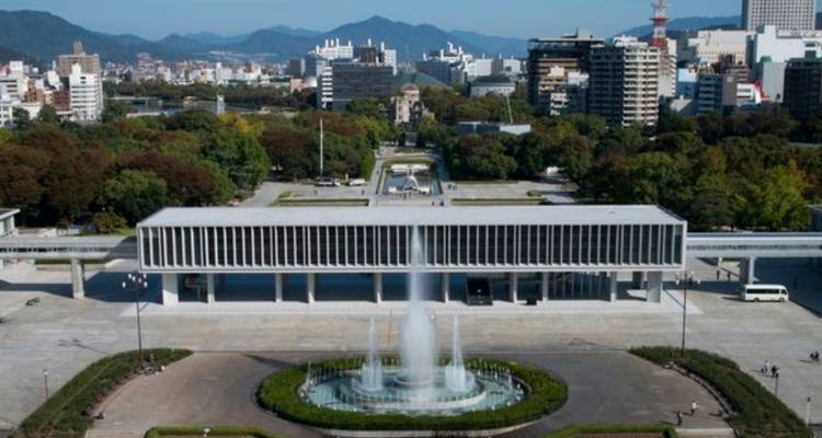 Vista aérea del complejo del Museo Conmemorativo de la Paz de Hiroshima con fuente y el horizonte de la ciudad más allá.