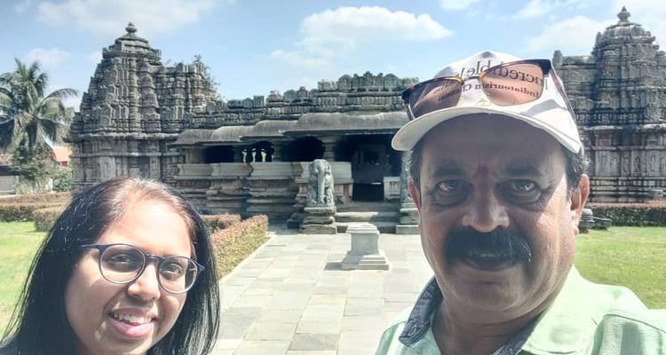 Dos personas tomándose una selfie frente a un templo antiguo.