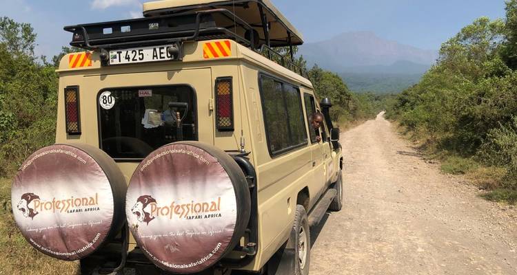 Safari vehicle with Mount Kilimanjaro in the background.