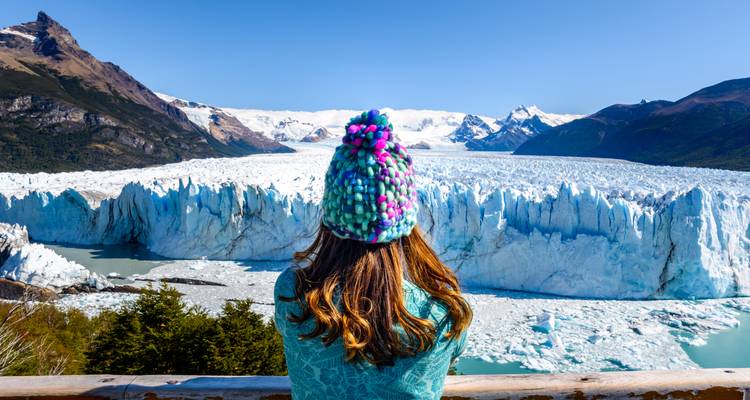Eine Person in bunter Winterkleidung mit Blick auf den Perito-Moreno-Gletscher.
