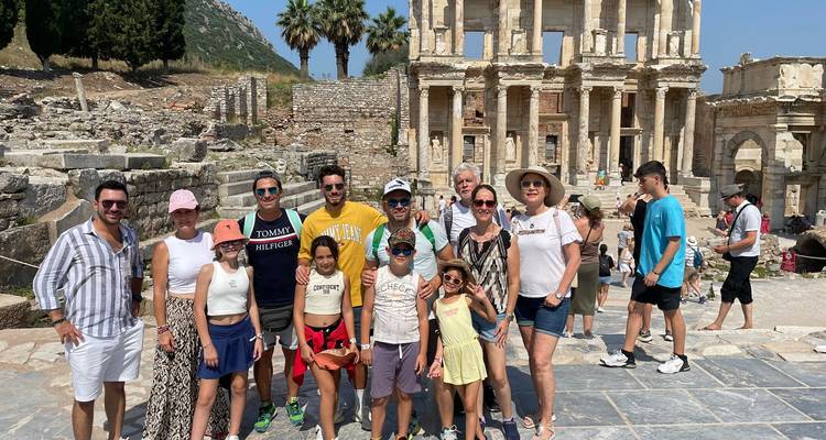 Gruppe von Touristen, die vor antiken Ruinen stehen.