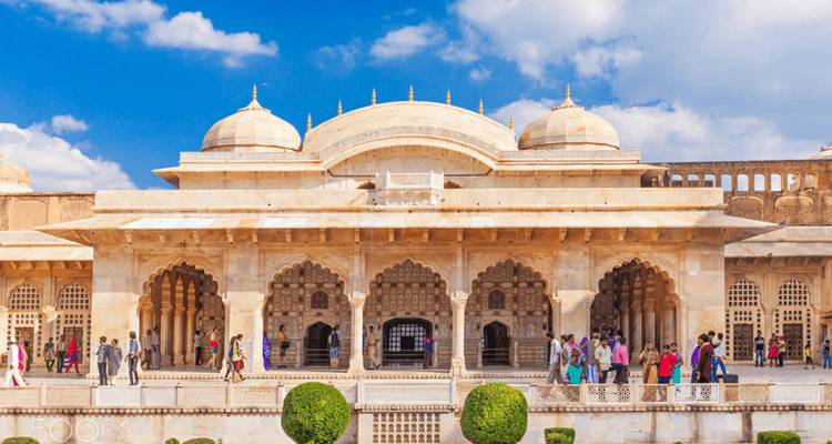 Een historisch paleis met gebeeldhouwde steenwerk en mensen eromheen.