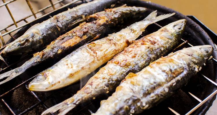 Grilled sardines on a charcoal grill.