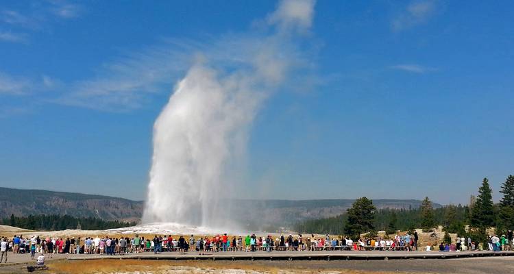 Crowds watching the eruption of Old Faithful geyser.