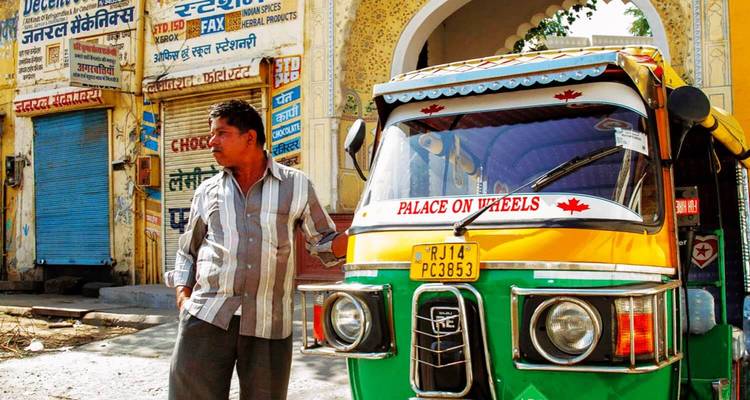 Homme debout à côté d'un pousse-pousse coloré.
