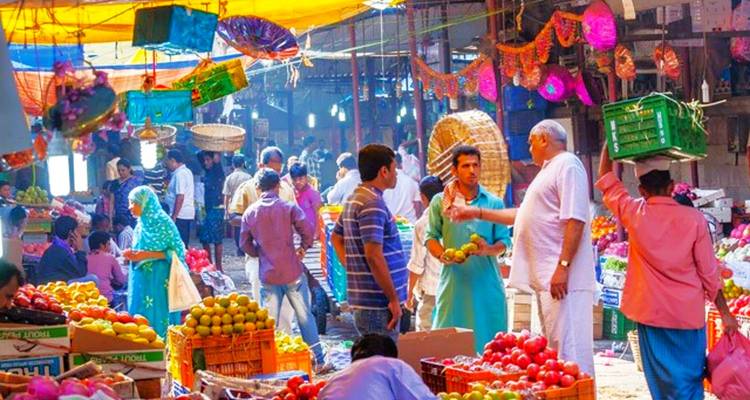 Marché en plein air animé avec des gens qui vendent et achètent des marchandises.