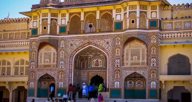 Entrée détaillée d'un bâtiment historique coloré avec des personnes.