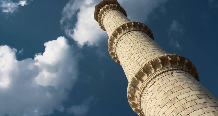 Gros plan d'un grand minaret en pierre contre le ciel.