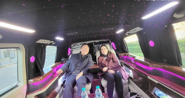 Pareja sentada dentro de una camioneta de lujo con iluminación de neón púrpura y LEDs en el techo que parecen estrellas