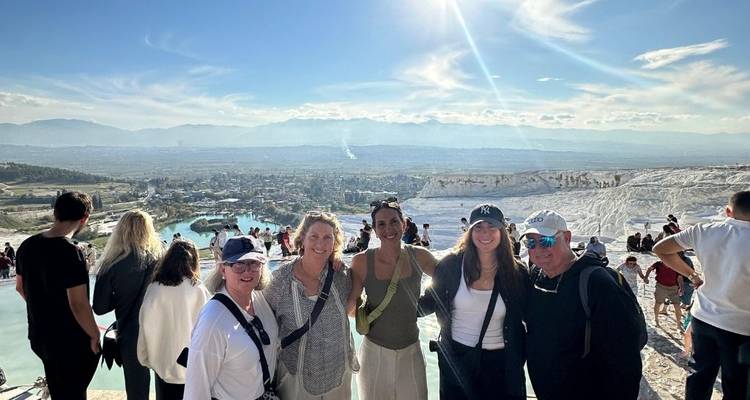 Un grupo de personas con una vista panorámica de Pamukkale detrás.