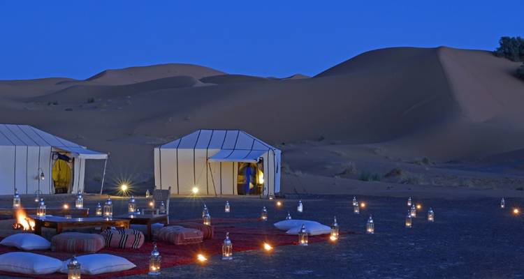 Woestijnkampeerplaats met tenten en lantaarns 's nachts in Jaisalmer.