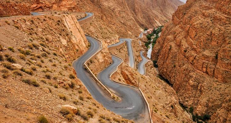 A winding road cutting through rocky desert terrain.