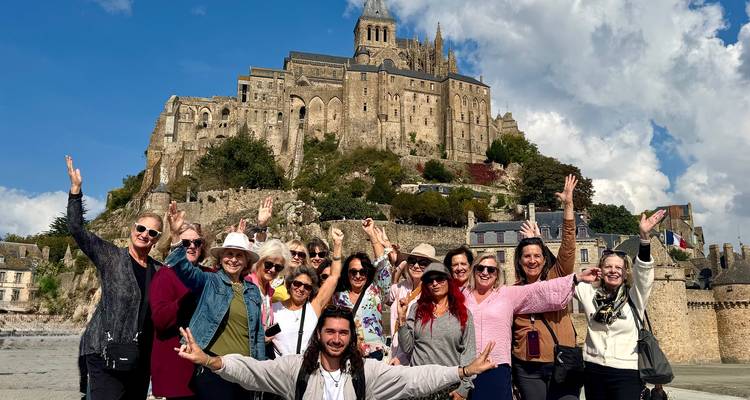 Groupe de personnes posant avec un château historique en arrière-plan.