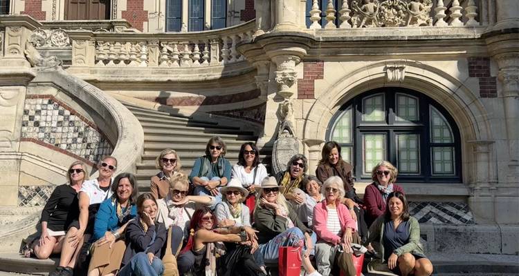 Groupe de personnes assises sur les marches d'un bâtiment historique.