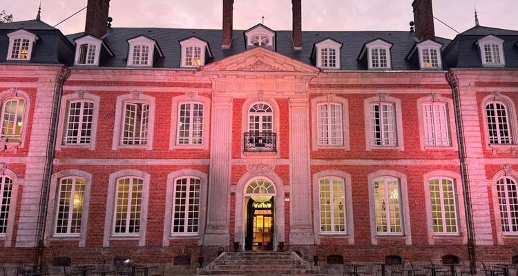 Élégant bâtiment avec éclairage rose au crépuscule.