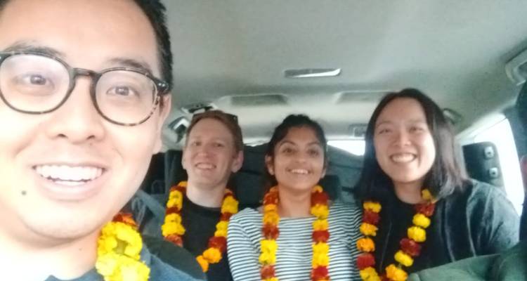 Gruppenfoto von Personen in einem Fahrzeug mit Girlanden.