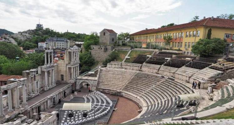 Anfiteatro romano antiguo con edificios circundantes.