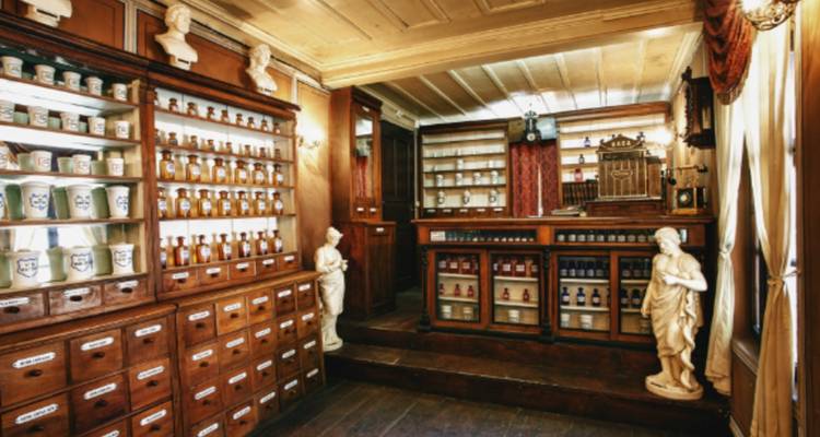 Interior de una antigua botica con estantes de frascos.
