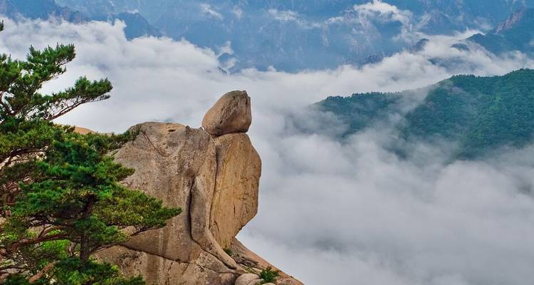 A rocky mountain peak surrounded by clouds.