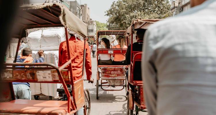 Cycle rickshaws packed in a busy narrow street of Old Delhi on a bright afternoon