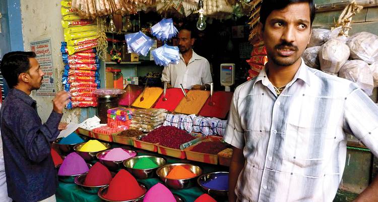 Vibrant spice and goods market with colorful displays.