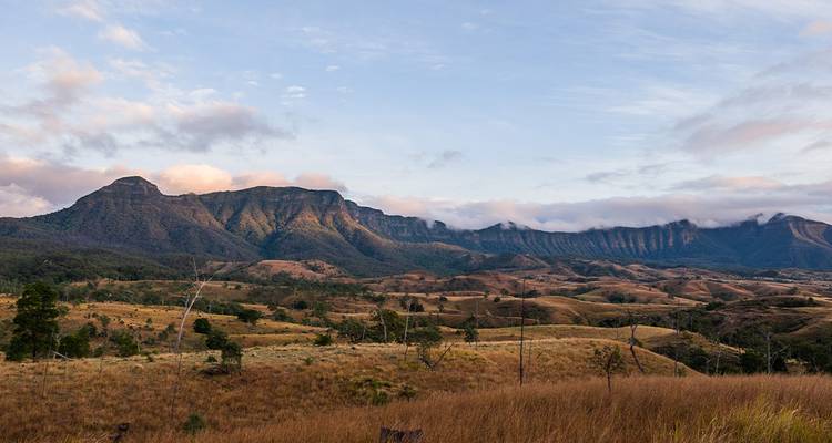Vue panoramique des montagnes sous un ciel partiellement nuageux.
