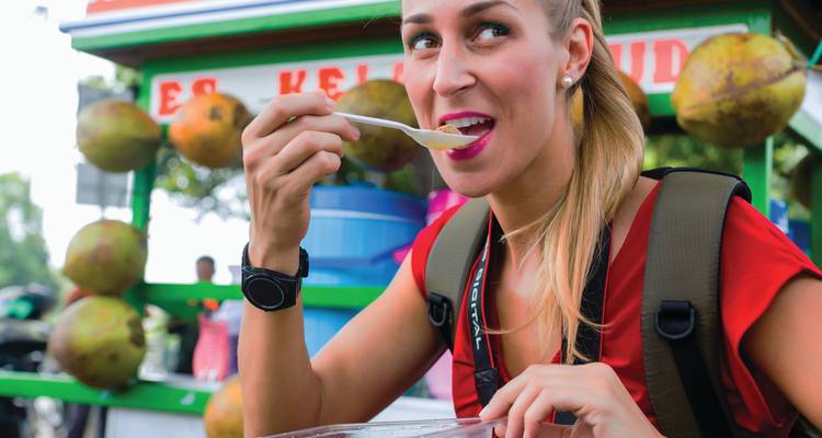 Personne savourant de la nourriture de rue à un stand de vendeur.