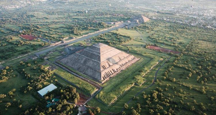 Vue aérienne d'une grande pyramide et du paysage environnant.