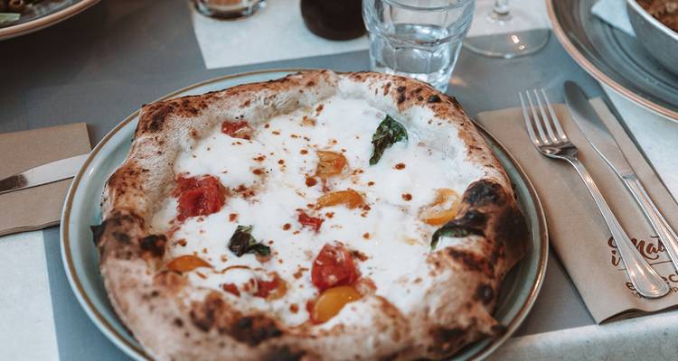 Plate of pizza on a table.