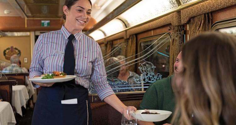 Restauratiewagon van een trein met passagiers en personeel.