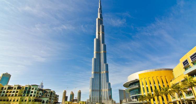 De majestueuze Burj Khalifa steekt af tegen een helderblauwe hemel, omringd door moderne architectuur van Dubai.