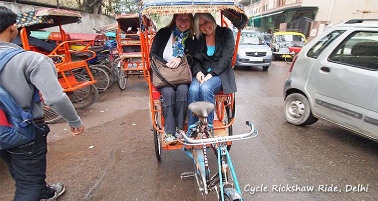 Twee mensen genieten van een rit in een fietsriksja in een levendige stad.