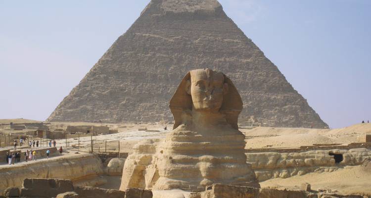 Sphinx mit der Großen Pyramide im Hintergrund unter einem klaren Himmel.