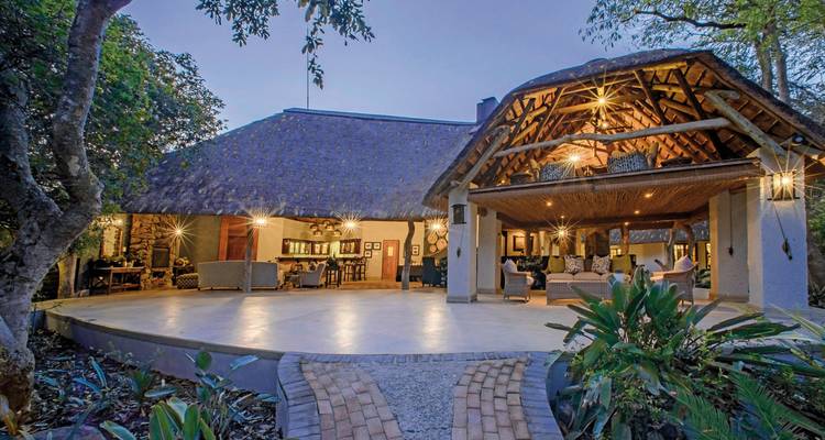 Thatched lodge exterior with open-air living space.