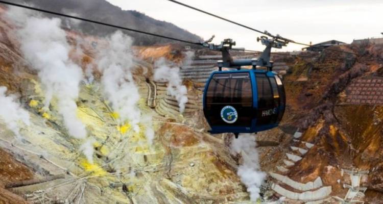 Cable car in a volcanic landscape with fumaroles.