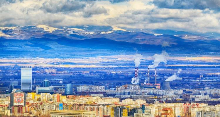 Paysage urbain avec vue sur les montagnes et la zone industrielle.