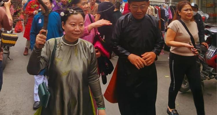 Mensen die deelnemen aan een straatfestival in traditionele kleding.