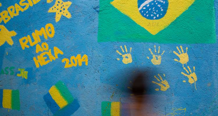 Muur met kleurrijke muurschilderingen en een Braziliaanse vlag.