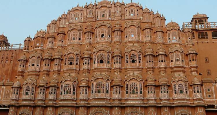Ingewikkelde honingraatgevel van Jaipur's Hawa Mahal die gloeit in zacht licht