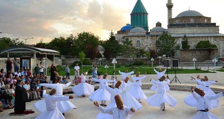 Derviches tourneurs se produisant en plein air devant une mosquée.