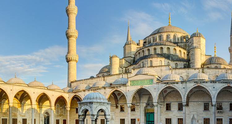 Mosquée historique avec dômes et minarets sous un ciel dégagé.