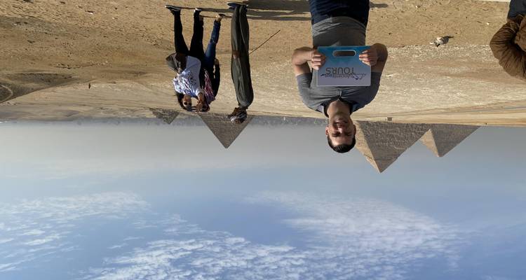 Toeristen die poseren voor piramides in de woestijn.