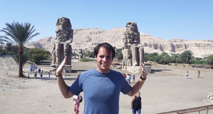 Man poseert met tweelingbeelden en woestijnachtergrond.